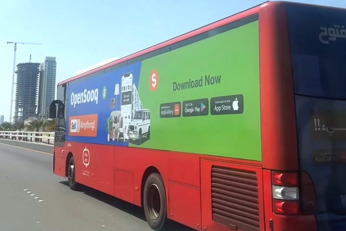 A public bus in Bahrain with its full side wrapped in OpenSooq advertising